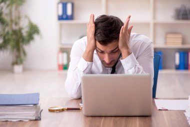 Genç işadamı işyerinde oturuyor.