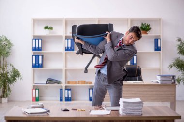 Genç işadamı işyerinde oturuyor.