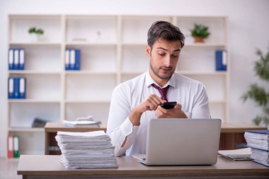 Genç işadamı işyerinde oturuyor.