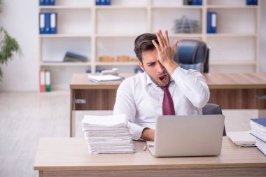 Genç işadamı işyerinde oturuyor.