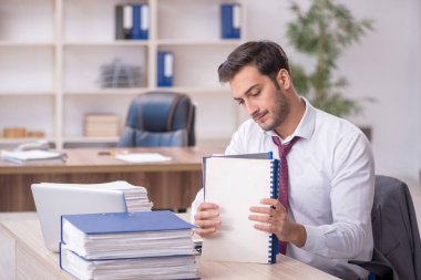 Genç işadamı işyerinde oturuyor.