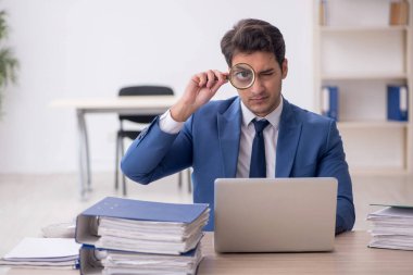 Genç işadamı ve işyerinde çok fazla iş var.