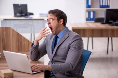 Genç işadamı işyerinde oturuyor.