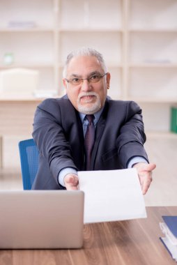 Ofiste çalışan eski bir işadamı.