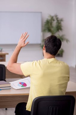 Young student teacher sitting in the classroom