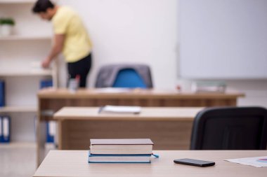 Young student teacher sitting in the classroom