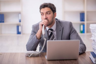 Genç bir çalışan ve ofiste çok fazla iş var.