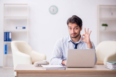 Genç işadamı işyerinde oturuyor.