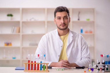 Young chemist sitting at the lab