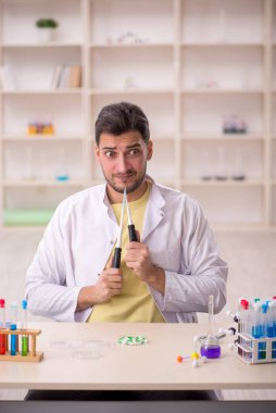 Young chemist sitting at the lab