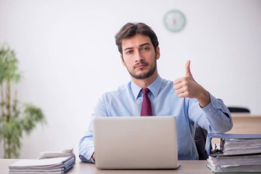 Genç işadamı işyerinde oturuyor.