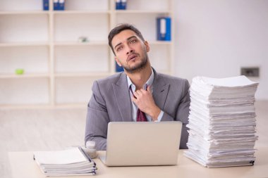 Young employee and too much work at workplace