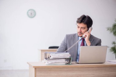 Ofiste telefonla konuşan genç bir çalışan.