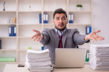 Young employee and too much work at workplace