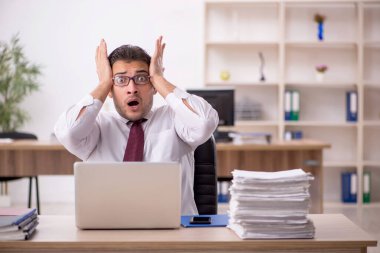 Genç işadamı ve işyerinde çok fazla iş var.