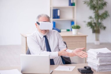 Old businessman employee wearing virtual glasses in the office