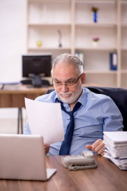 Ofisteki aşırı işten memnun olmayan eski bir işadamı.