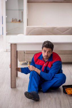 Evde çalışan genç bir marangoz.