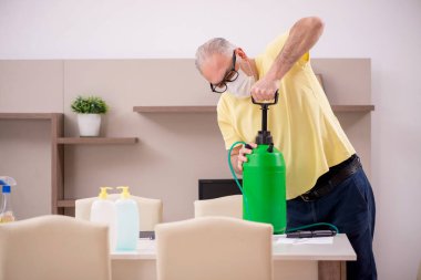 Yaşlı adam evi temizliyor.