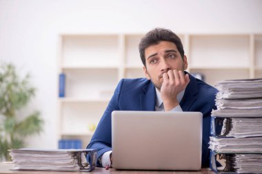 Genç işadamı ve işyerinde çok fazla iş var.