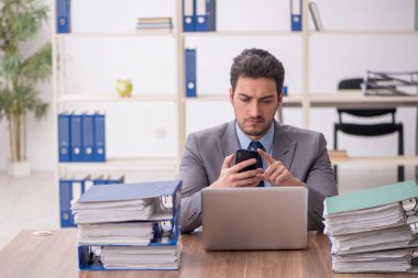 Young employee and too much work at workplace