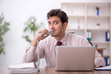 Genç işadamı ve işyerinde çok fazla iş var.