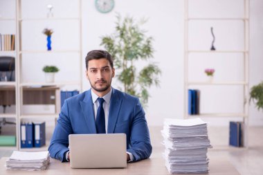 Genç bir çalışan ve ofiste çok fazla iş var.