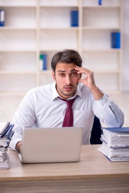 Genç işadamı ve işyerinde çok fazla iş var.