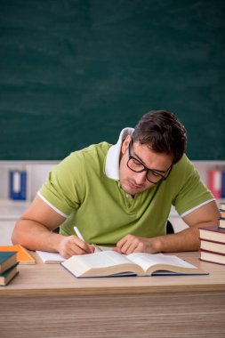 Sınıfta tahtaya oturan genç bir öğrenci.