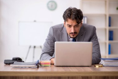 Genç işadamı işyerinde oturuyor.