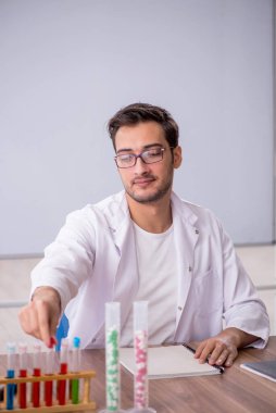 Young chemist in front of white board