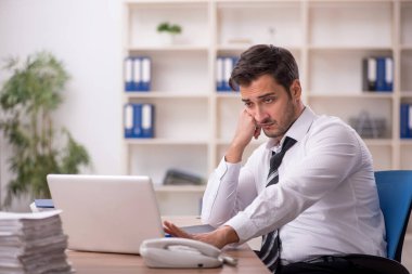 Genç işadamı işyerinde oturuyor.