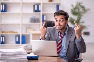 Genç işadamı işyerinde oturuyor.