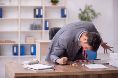 Genç işadamı işyerinde oturuyor.