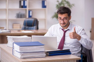 Genç işadamı işyerinde oturuyor.