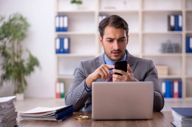 Genç işadamı işyerinde oturuyor.