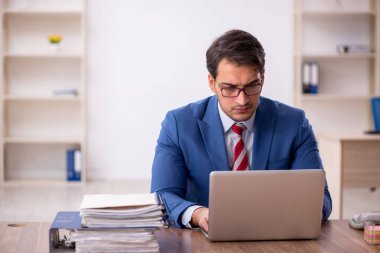 Genç işadamı işyerinde oturuyor.