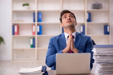 Genç işadamı ve işyerinde çok fazla iş var.