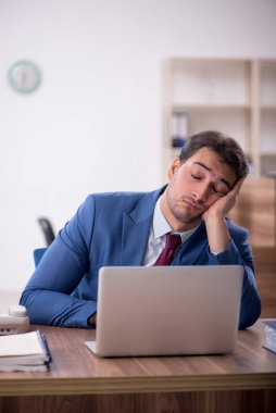 Genç işadamı işyerinde aşırı çalışmaktan memnun değil.