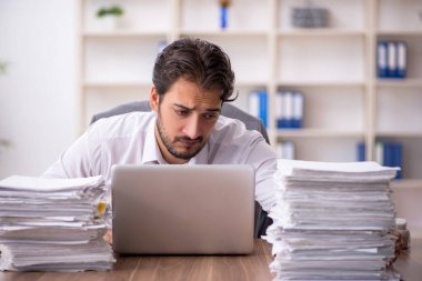 Genç işadamı ve ofiste çok fazla iş var.