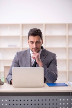 Genç işadamı işyerinde oturuyor.