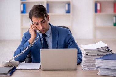 Genç işadamı ve ofiste çok fazla iş var.