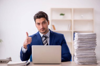 Young employee and too much work at workplace