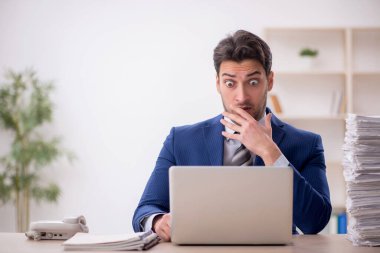 Young employee and too much work at workplace