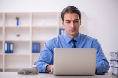 Genç işadamı ve işyerinde çok fazla iş var.