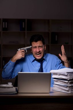 Young employee working late at workplace