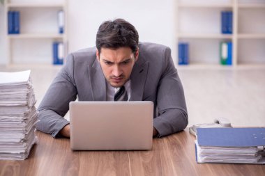 Genç bir çalışan ve ofiste çok fazla iş var.