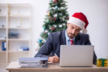 Genç çalışan Noel 'i ofiste kutluyor.