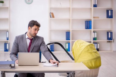 Young employee looking after newborn in the office