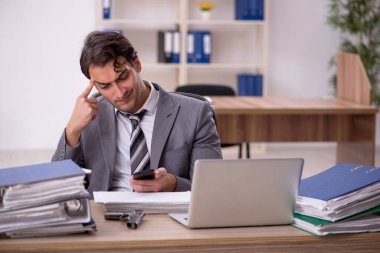 Ofisteki aşırı işten memnun olmayan genç bir çalışan.